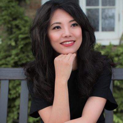 Chenyin Li smiles in a black top and blue jeans
